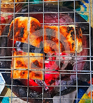 This square-shaped cake made from white sticky rice is baked over hot coals in a brazier until it turns blackish brown