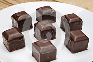 Square-shaped chocolates on a white plate on the table