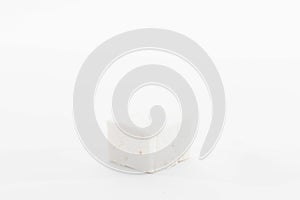 a square stone that is on top of a white surface