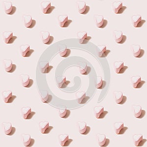 Square shaped isometric pattern created of heart marshmallows in pink and white color. 45 degree angle on pastel beige color