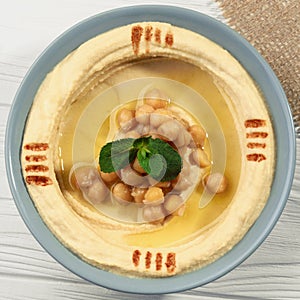 Square shot of Top view of hummus plate on wooden table