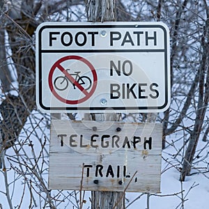 Square Signages by a foot path trail at Wasatch Mountains blanketed with snow in winter