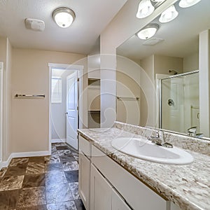 Square Sink and mirror in front of bathtub and shower stall inside tile floor bathroom