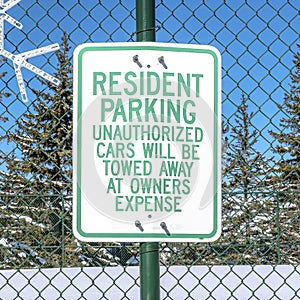 Square Snowflake decor and Resident Parking sign on green mesh wire fence in Park City