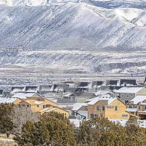 Square Snowy mountain and aerial view of houses in Utah Valley neighborhood in winter