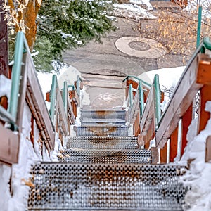 Square Stairway going down to a road on a hill with fresh white snow in winter