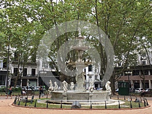 Square surrounded by statues and trees photo