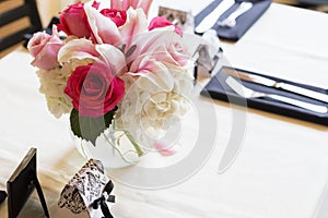 Square table with white table cloth decorated for wedding
