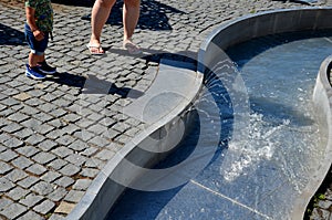 On the square there are spray nozzles in a regular grid which spray upwards according to the program. the girls are fooling around