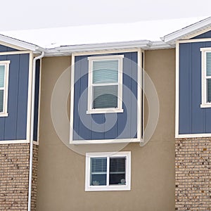 Square Townhome exterior with sliding glass windows brick walls and vertical sidings