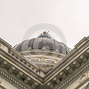 Square Utah State Capitol building and dome in Salt Lake City against bright cloudy sky