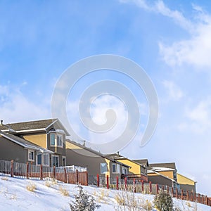 Square Wasatch Mountain residential area with homes against clouds and blue sky