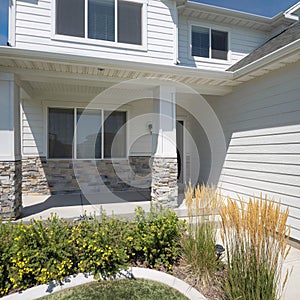 Square Whispy white clouds Facade of a house with traditional design and front yard garden