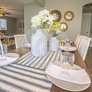 Square White dinnerware and table runners at the dining room of a family home