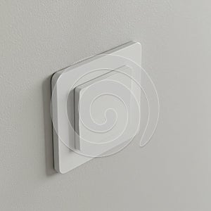 Square white light switch mounted on a smooth, light gray wall. The switch features a