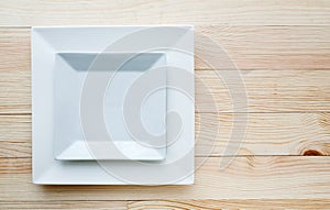 Square white plates over wooden table