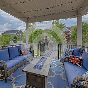 Square White puffy clouds Cozy outdoor deck with fire pit table and woven sofas with blue