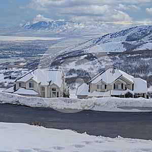 Square White puffy clouds Uphill snowy residential area at Draper in Utah with a view of W