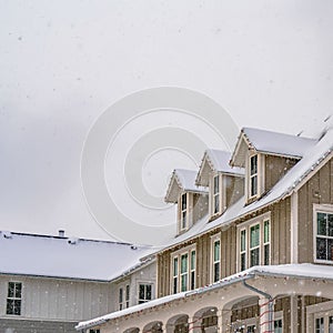 Square Winter scene with cozy homes and wooden fences under a cloudy sky in Daybreak