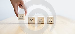 This square wooden block with emoticons is used to allow customers to assess their satisfaction after using the service. photo