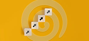 Square wooden blocks are placed on a yellow background, on the wooden blocks there are arrow contracts and line up. Wood block photo