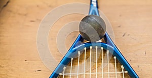 Squash ball on court with squash racket ready to play new game