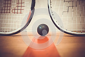 Squash ball between two squash rackets