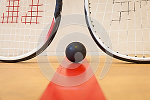 Squash ball between two squash rackets