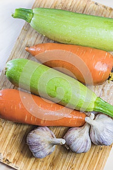 Squash and carrots and garlic on a chopping board