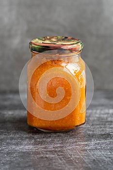 Squash caviar in a jar on a black background