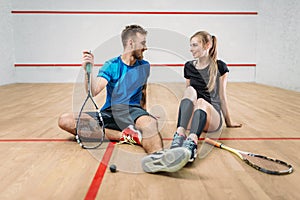 Squash game concept, young couple, rackets, ball