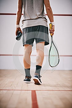 In a squash league of his own. an unrecognisable man playing a game of squash.