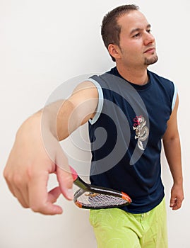 Squash player leans racket