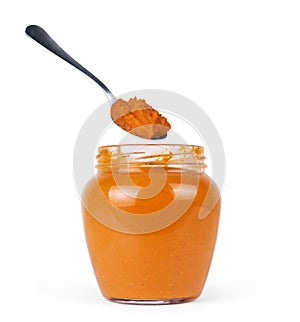 Squash puree in a glass jar on a white background