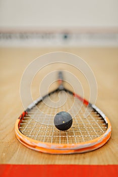 Squash rackets and ball on court floor closeup