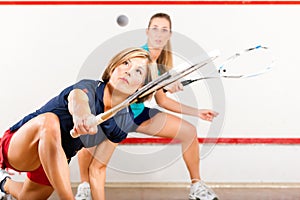 Squash sport - women playing on gym court