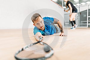 Squash training, player with racket lies on floor