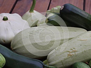 Squashes and patisons on a wooden terrace.