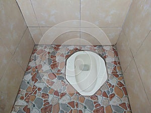 Squat toilets are commonly used in homes, hotels, inns, home stays and public places photo