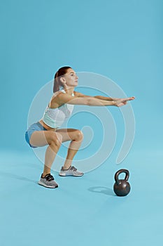 Squats. Fitness woman in sports wear exercising, doing squat