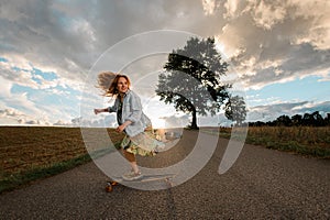 Squatting elegance. Girl exhibits grace in longboard riding, viewed below.