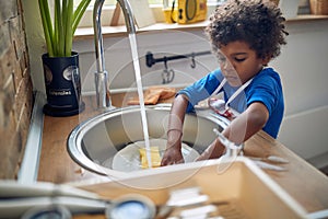 Squeaky Clean Adventures: Afro-American Boy\'s Sudsy Dishwashing Excitement