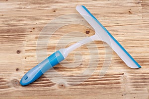 A squeegee or squilgee, tool with a flat, smooth rubber blade, used to remove or control the flow of liquid on a flat surface on w