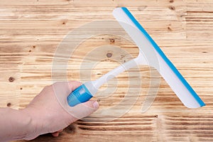 A squeegee or squilgee, tool with a flat, smooth rubber blade, used to remove or control the flow of liquid on a flat surface on w