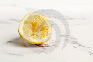 Squeezed half lemon on marble table