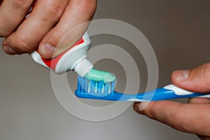 Squeezes toothpaste on the brush