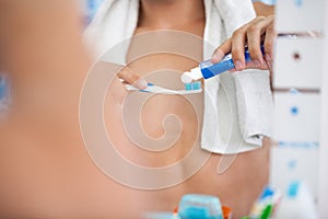 Squeezes toothpaste on the brush