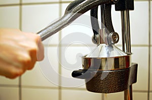 Squeezing an orange with a manual press.