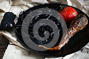 Squid ink colored black noodles with char-grilled tomato, creative
