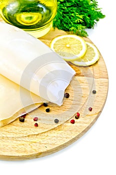 Squid with lemon and oil on a round board